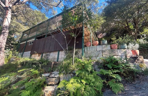 Umina Beach House | Treetops retreat - pole house set against a sandstone rock face in the tree tops