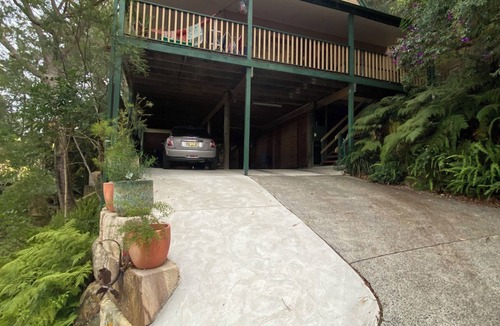 Umina Beach House | Treetops retreat - pole house set against a sandstone rock face in the tree tops
